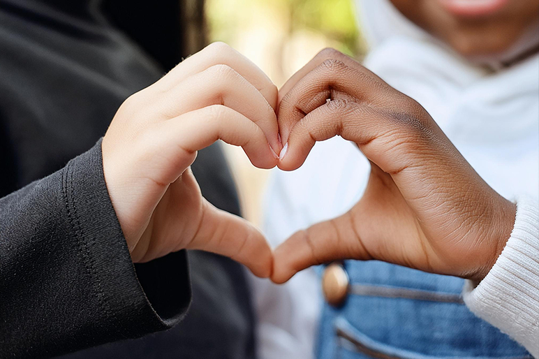 des enfants forment un coeur avec la main