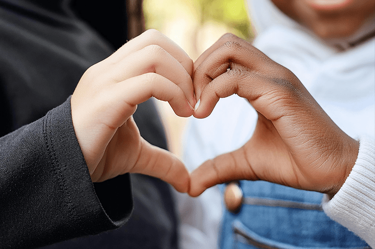 des enfants forment un coeur avec la main